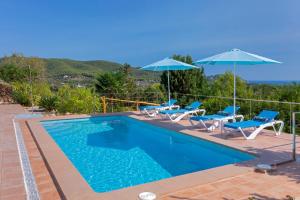 una piscina con sillas y sombrillas en una casa en Charming villa with pool, Can Toni Mateu., en Sant Carles de Peralta
