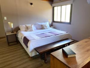 a bedroom with a bed with a table and a window at El Lagar de Uco in La Consulta +38 photos