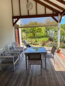 un patio con mesa y sillas en una terraza en cocon caraibe, en Sainte-Anne