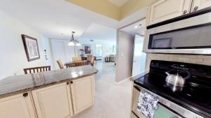 a kitchen with a stove and a microwave at Beachfront condo with 2 pools and direct beach access in Miami Beach