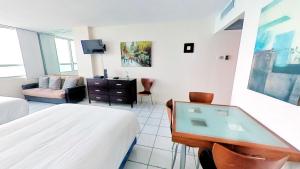 Una habitación con un dormitorio con una cama y un escritorio. en Castle 1033, en Miami Beach