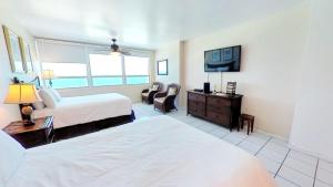 a hotel room with two beds and a flat screen tv at Castle 922 in Miami Beach