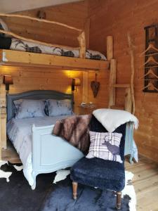 a bedroom with a white bed and a chair at Le Cerf d'Hubert in Redu