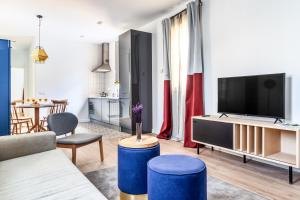 a living room with a couch and a tv at Smartr Atocha Reina Sofia in Madrid