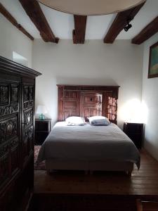 een slaapkamer met een groot bed met een houten hoofdeinde bij Appartement de charme au Manoir ! in Le Relecq-Kerhuon