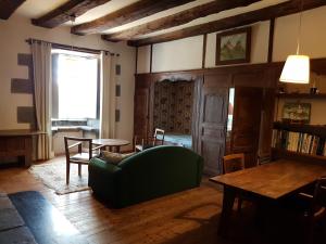 Una sala de estar con un sofá verde y una mesa. en Appartement de charme au Manoir !, en Le Relecq-Kerhuon