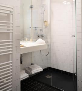a bathroom with a sink and a shower at Hôtel Helzear Etoile by Esteem in Paris