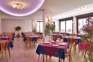 a dining room with tables and chairs with purple tablecloths at Hotel Sorriso in Bellaria-Igea Marina