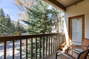 a balcony with two chairs and a view of trees at Townsend Place by Vail Realty in Beaver Creek