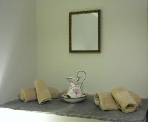 a shelf with a mirror and a bowl on it at Merlin Cottages in Llandovery