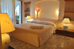 sypialnia z dużym łóżkiem z dużym lustrem w obiekcie Sea & Beach Apartments Porto Cervo Costa Smeralda w mieście Porto Cervo
