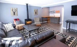 藍山的住宿－4 Bedroom Rustic Chalet，客厅设有真皮沙发和壁炉
