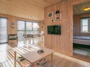 6 person holiday home in Fjerritslev في Fjerritslev: غرفة معيشة مع جدار خشبي مع تلفزيون وطاولة