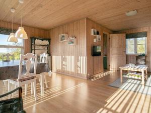 - un salon avec des murs en bois, une table et des chaises dans l'établissement 6 person holiday home in Fjerritslev, à Fjerritslev