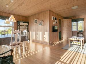 a living room with wooden walls and a table and chairs at 6 person holiday home in Fjerritslev in Fjerritslev