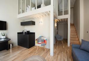 a living room with a loft bed and a couch at Suites & Hôtel Helzear Etoile in Paris