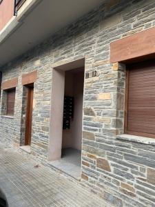 a stone wall with a door and a garage at Piso de Verena in Guardiola de Berguedà