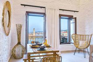 una sala da pranzo con tavolo e balcone di Vista Del Porto Luxury Suites a Rethymno