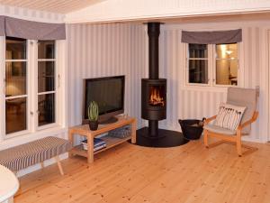 a living room with a fireplace and a television at Holiday home Idestrup VIII in Marielyst
