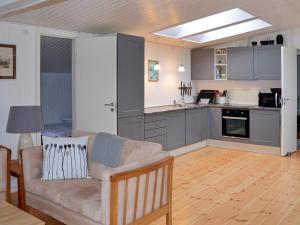 a living room with a couch and a kitchen at Holiday home Idestrup VIII in Marielyst