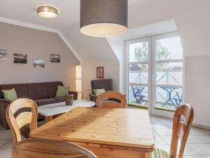 a living room with a table and chairs and a couch at Cozy Apartment in Insel Poel near Beach in Oertzenhof