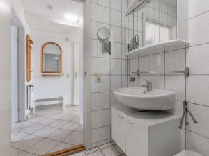 a white bathroom with a sink and a mirror at Charmante Ferienwohnung in Kirchdorf Insel Poel in Oertzenhof +32 photos