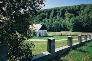 a house in the middle of a field with a fence at Pradnik Valley Lodge in Prądnik Korzkiewski