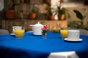 una mesa azul con una vela y dos vasos de zumo de naranja en Casa Rosales, en Medellín