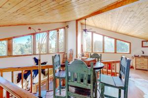 a dining room with a table and chairs and windows at Appaloosa Retreat in Pagosa Springs