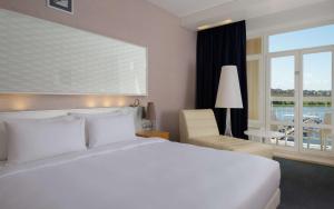 Un dormitorio con una gran cama blanca y una ventana en Radisson Resort, Zavidovo, en Zavidovo