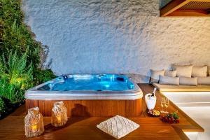 Vista Del Porto Luxury Suites في مدينة ريثيمنو: جاكوزي في غرفة مع طاولة