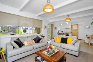 Sala de estar con 2 sofás y mesa en Cosy Cottage 2BR, NETFLIX, Private Garden Terrace, en Korumburra