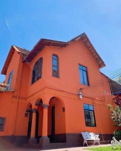 una casa naranja con un cielo azul en el fondo en Pousada e Restaurante Tio Paulo, en Teresópolis