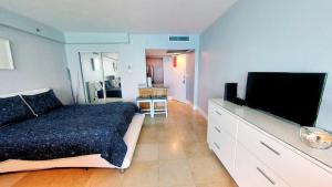 a bedroom with a bed and a flat screen tv at Oceanfront views, balcony & gym, bars, beach access and free parking! in Miami Beach