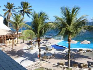 a resort with palm trees and a swimming pool at Mercure Salvador Rio Vermelho in Salvador