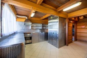 una cucina con elettrodomestici in acciaio inossidabile e soffitti in legno di Wille Trójca a Trójca