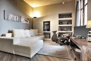 un soggiorno con divano, tavolo e TV di Confortevole appartamento in centro a LA MORRA a La Morra