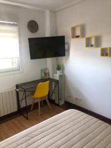 1 dormitorio con escritorio y silla amarilla en El Pinar de Mogro, en Mogro