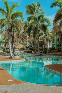 a swimming pool with palm trees in a resort at Aquatika Paraíso Tropical in Loiza