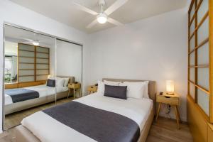 a bedroom with two beds and a mirror at The Docks On Goodwin in Brisbane