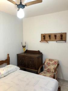 1 dormitorio con 1 cama, 1 silla y ventilador de techo en Chalé Pura Vida en São Roque de Minas