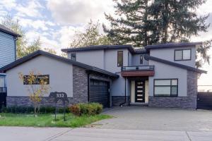 a white house with a black garage at 5-Star Luxury and comfortable home in New Westminster