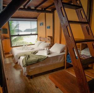 two bunk beds in a room with a cat sitting on them at Mar da Lua in Praia de Araçatiba