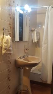 a bathroom with a sink and a toilet and a mirror at Posta del Ángel - Salta in Salta