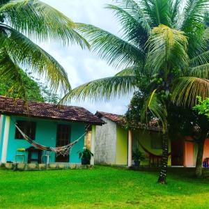 昆幕露夏其巴的住宿－Hospedaria Caribe，前面有棕榈树的房子