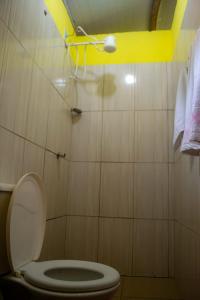 Hospedaria Caribe في كوموروكساتيبا: حمام مع مرحاض وسقف أصفر