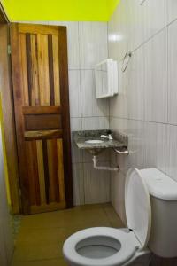 łazienka z toaletą i umywalką w obiekcie Hospedaria Caribe w mieście Cumuruxatiba