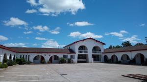 a large white building with a parking lot at Espana Motel in Grafton