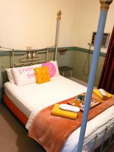 1 cama con 2 almohadas y bandeja de comida en The Comfort Cottage on Williams, en Broken Hill