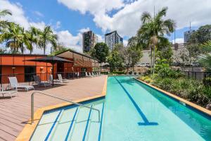 a swimming pool with a pool table and chairs at The Docks On Goodwin in Brisbane